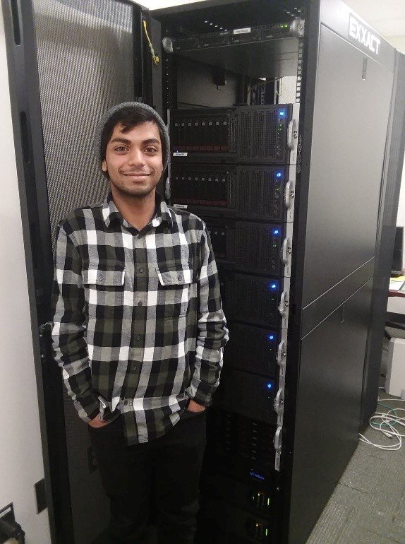 Dipto Mukherjee as an undergraduate standing in front of a GPU-enabled rack-mounted computing cluster