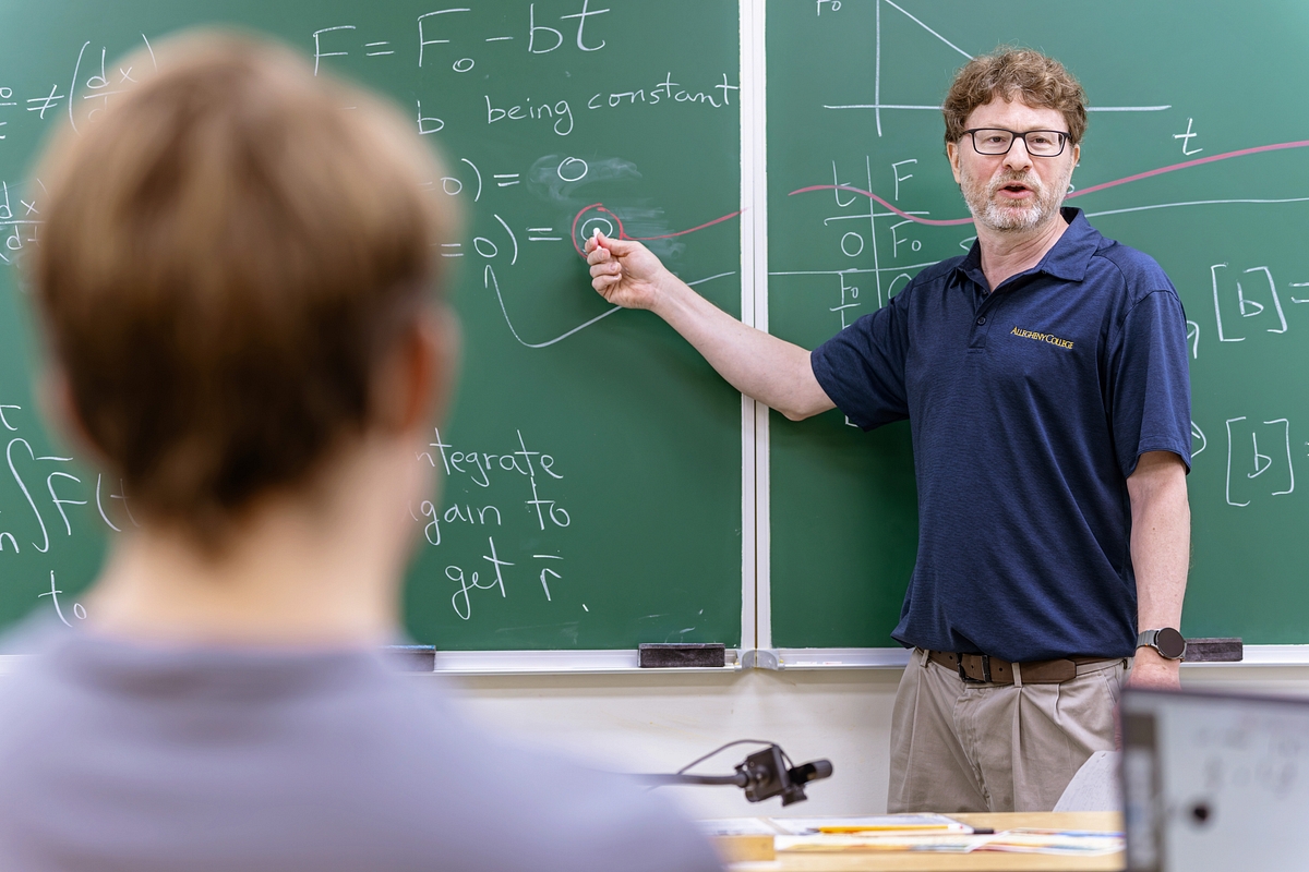 Jamie Lombardi teaching physics at a chalkboard in an Allegheny College classroom